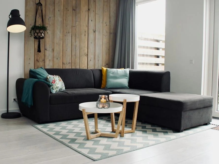 Canapé d’angle gris en tissu dans un salon lumineux